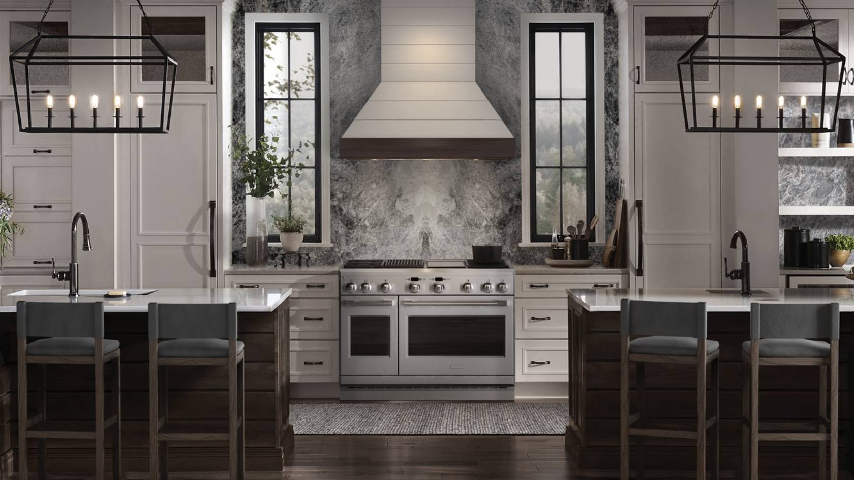 Monogram professional range and vent hood in a luxury kitchen with stone backsplash and twin islands